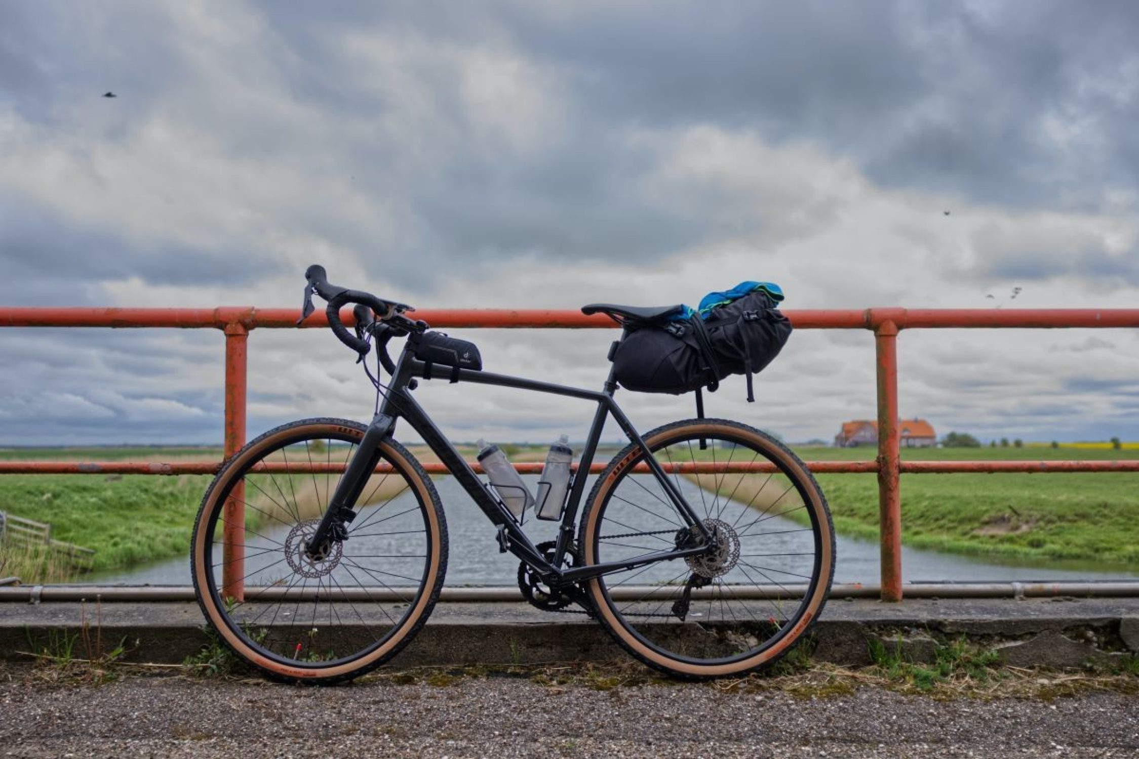 Velo mit Fahrradtaschen vor einem Geländer.