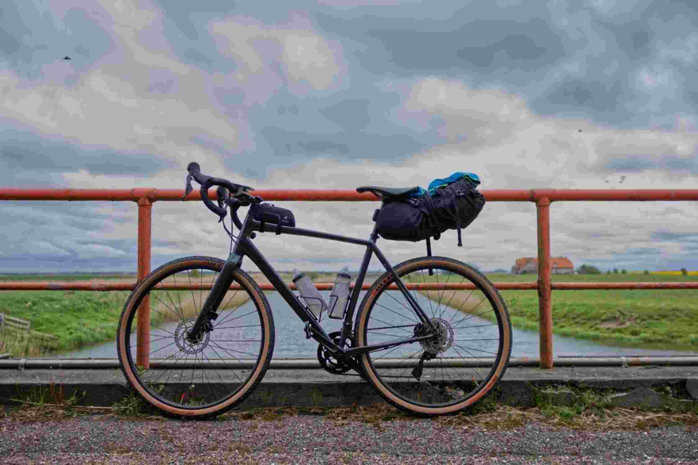 Velo mit Fahrradtaschen vor einem Geländer.