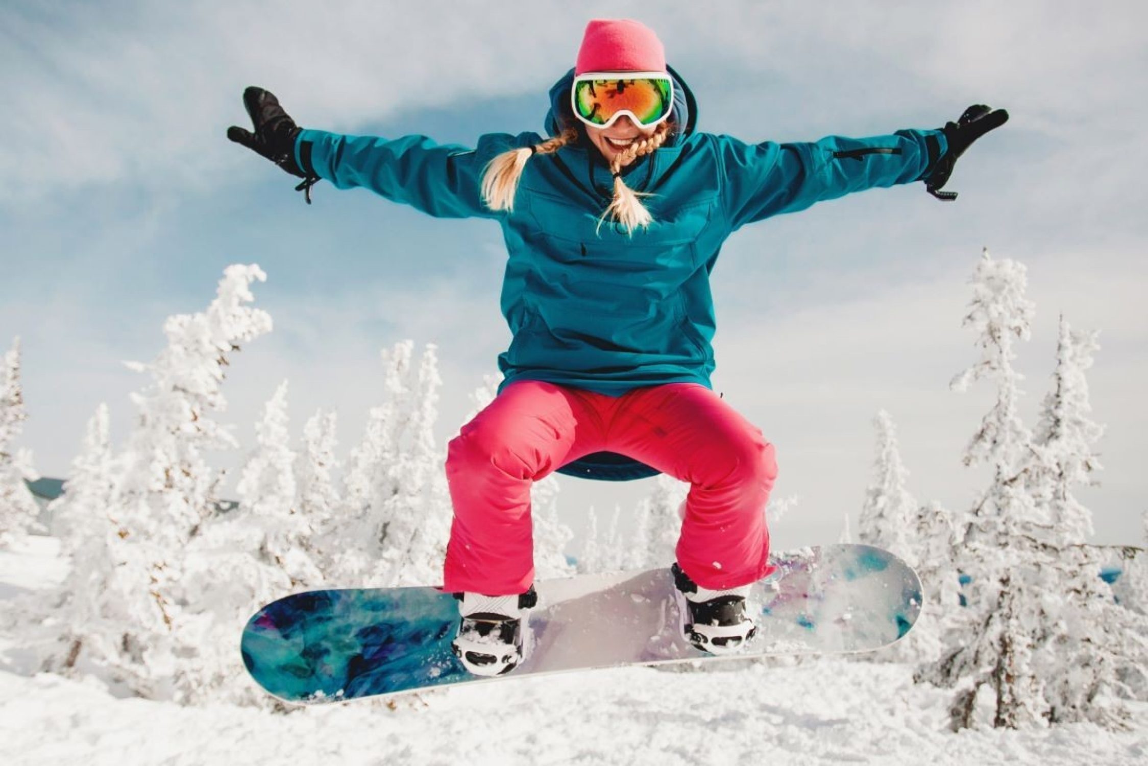 Snowboarderin welche aufspringt mit dem Board